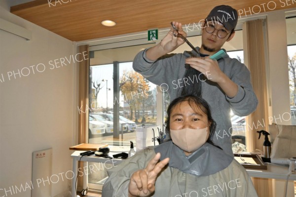 髪を切ってもらい笑顔を見せる施設利用者の女性