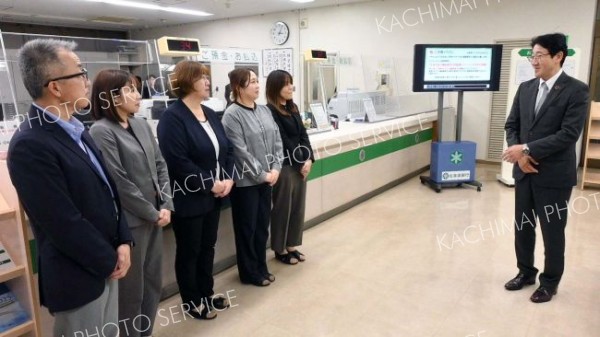 高橋支店長（左）ら道銀広尾支店の行員らをねぎらう高田代表取締役副頭取（右）