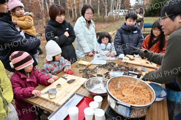 着火剤作りを体験する参加者らと作り方を説明する