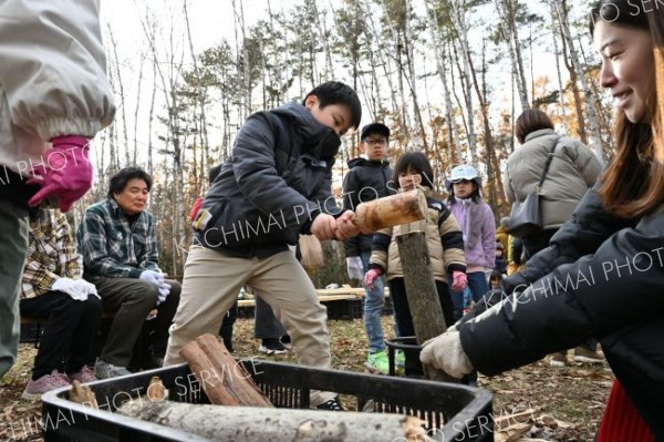 器具を使ってまき割りに挑戦する子ども