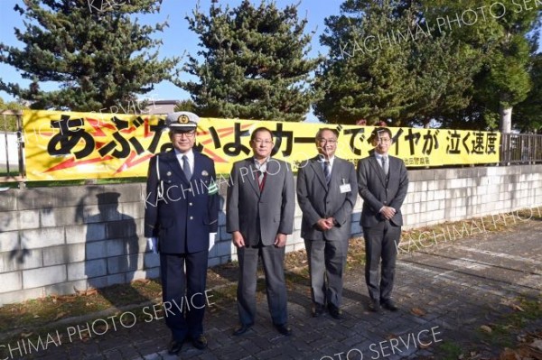 一新した横断幕と関係者