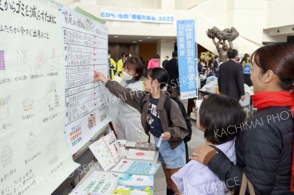 会場に展示されたパネルで環境保全について理解を深める来場者（１５日午前１０時半ごろ、長尾悦郎通信員撮影）