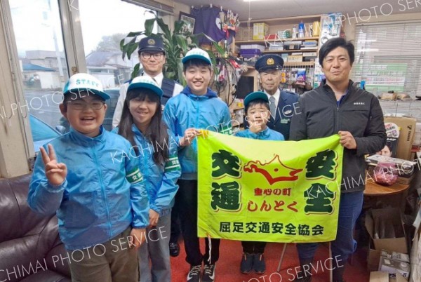 屈足自動車整備工場で交通安全を呼び掛け\た団員ら