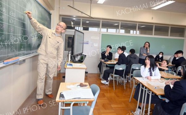 自ら考案したカードゲームで授業を行う山本さん（左）