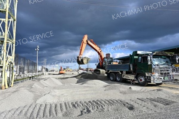 砂障害の砂利をトラックに移す作業を行う重機