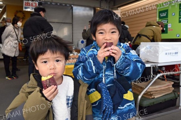 焼きたての地場産サツマイモを頬張る子ども（２２日午前１１時ごろ撮影）
