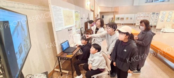 完成したホームページで昔の新得町を調べる子どもたち（１０月２６日、新得町の町民芸能芸術祭で）