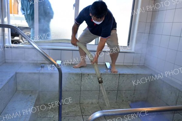 「あさひ苑」の浴槽にモール温泉を注ぎ込む町商工会青年部員