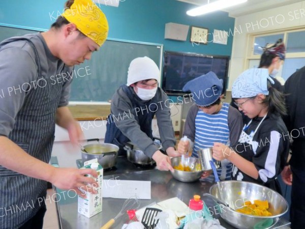 青年部員とカボチャ料理に取り組む児童たち