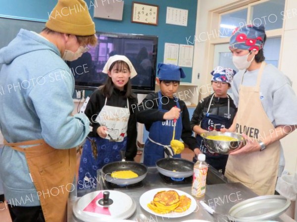 青年部員とカボチャ料理に取り組む児童たち
