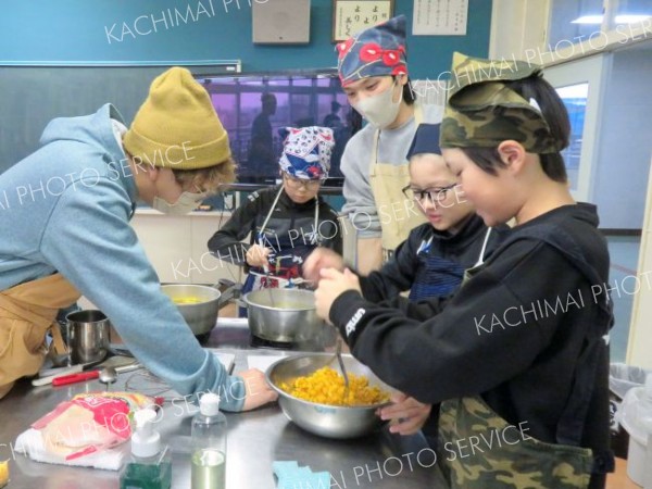 青年部員とカボチャ料理に取り組む児童たち