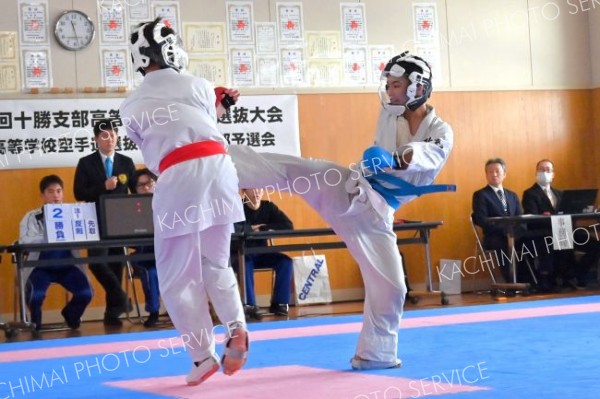 【男子個人戦組手・５５キロ以下級代表決定戦】岩佐梛斗（右、帯工）の中段蹴りが決まる