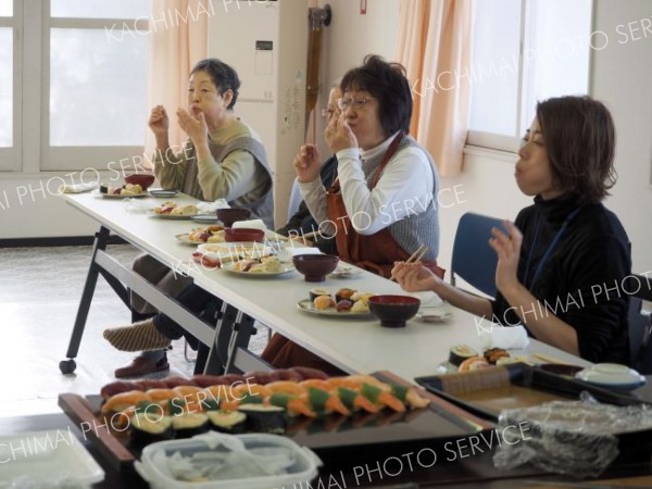 すしを味わいながら談笑する参加者
