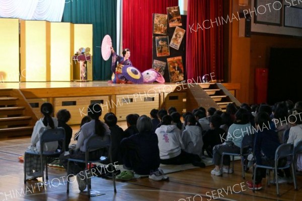 和妻のパフォーマンスに魅入る児童ら