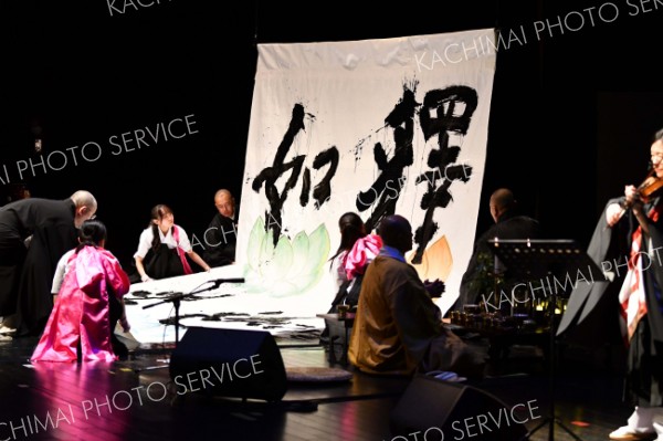 地元大学生による書道パフォーマンス。書かれた「釈迦如来」は、宗派を超えた「本尊」として大会会場に飾られた