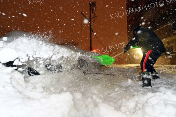 雪かきに追われる人（１４日午後７時半ごろ）