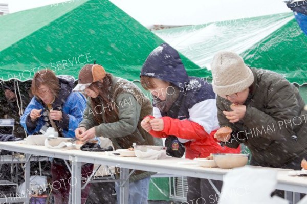 名物の「カニ早食い競争」。雪や寒さに負けず、食べる速度を早める参加者ら。貴重な旬の味、本当はゆっくり味わって食べたいのだが…
