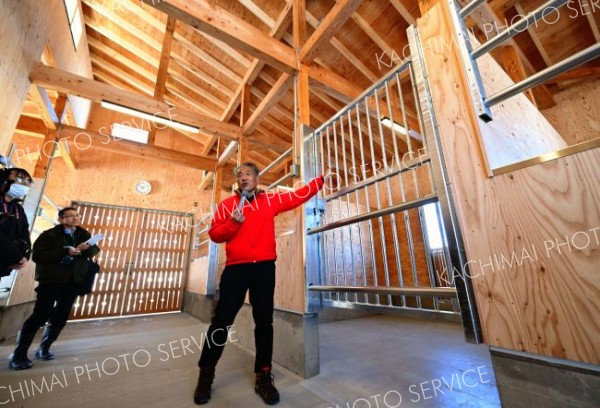 四つの馬房が配置された厩舎内を案内する（塩原真撮影）