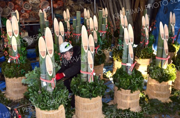 門松を飾り付ける従業員（１８日、塩原真撮影）