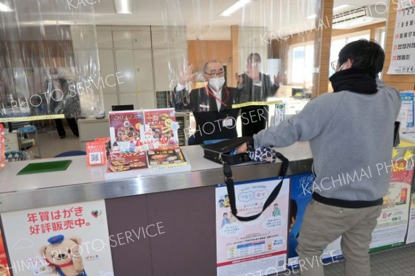 強盗役の警察官と相対する局員ら