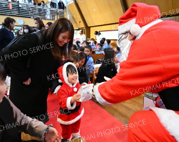 サンタがサンタにプレゼント。ちびっ子サンタは大喜び（１７日、帯広市の聖公会幼稚園で。塩原真撮影）