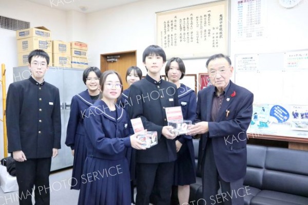 集まった募金を託す大樹中学校生徒会の役員ら