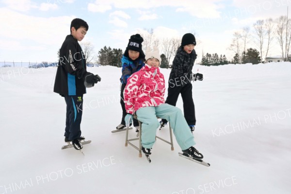 保護者らがつくったスケートリンクで楽しむ児童ら