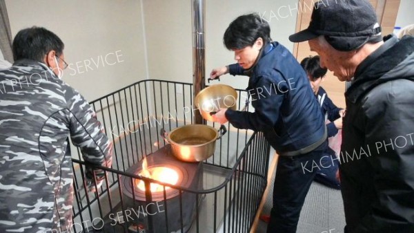 まきストーブを点火する参加者