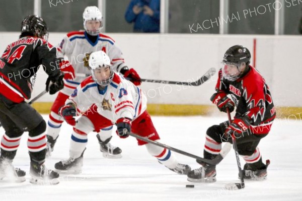 【決勝・駒大苫小牧―武修館】第３ピリオド、パックを奪い合う駒大苫小牧のＦＷ高嶋葉多（白色ユニホーム手前、札内中出）と武修感のＦＷ天内琉伍（右、豊頃中出）