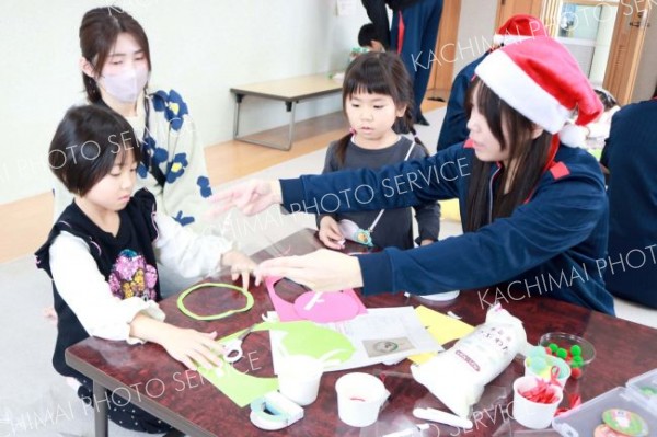 ボランティア部に教わりながらクリスマスの飾りつけを制作する子どもたち