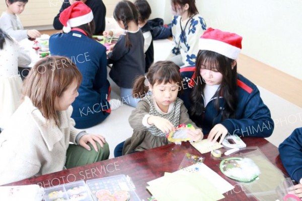 ボランティア部に教わりながらクリスマスの飾りつけを制作する子ども