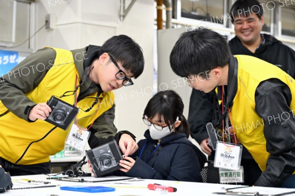 十勝毎日新聞社のスタッフらにカメラの使い方を教わる子ども
