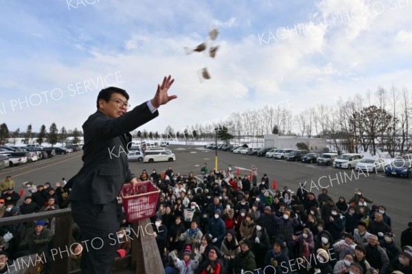 やぐらの上から紅白の餅をまく