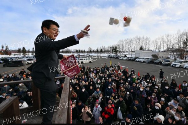 やぐらの上から紅白の餅をまく
