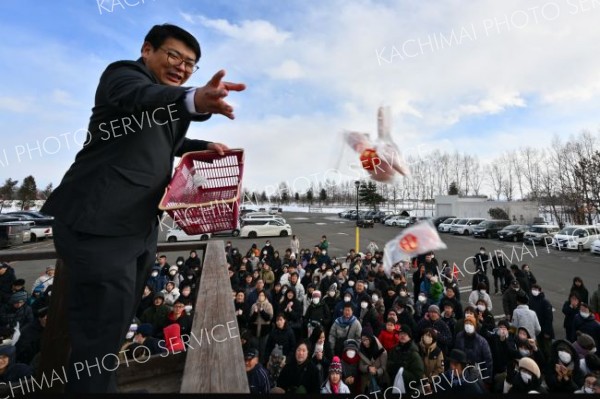 やぐらの上から紅白の餅をまく