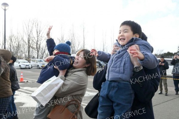 「こっち！」―。柳月スイートピア・ガーデンで行われた「新春もちまき」でとアピールする家族連れ。音更神社で祈祷を受けた紅白餅を求めて笑顔でアピール（１日正午ごろ、音更町の柳月スイートピア・ガーデンで）