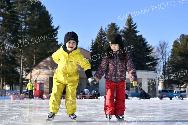 手をつなぎ氷の上を滑る子ども（６日、帯広市の緑ヶ丘公園市民リンクで。塩原真撮影）