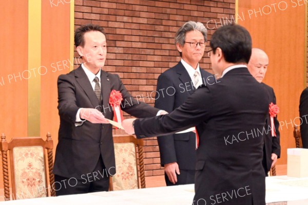 表彰状を受け取る