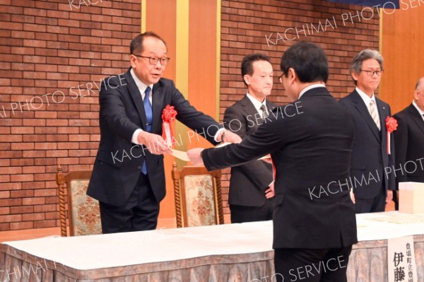 表彰状を受け取る