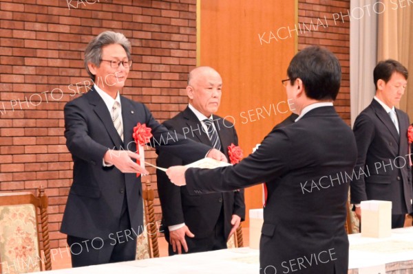 表彰状を受け取る