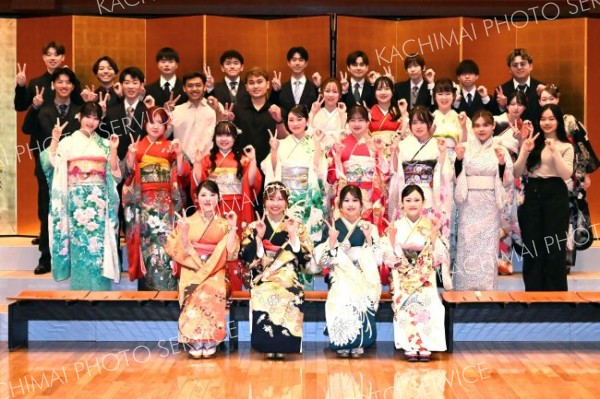 右手で２、左手で０をつくり記念撮影をする参列者たち（１１日、中札内、須貝拓也撮影）