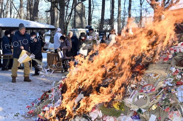 御神火が点火された焼納場に正月飾りを投げ入れる参拝者（１５日午前９時４０分ごろ、須貝拓也撮影）