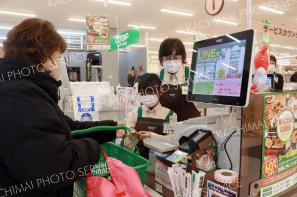 レジ打ちに挑戦する小学生