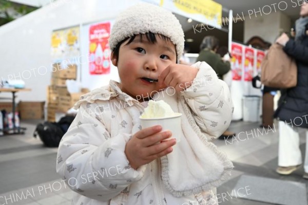 ミルク味、大好き―。「ミルク＆ナチュラルチーズフェア２０２６」で冷たいジェラートをほおばる子ども（９日、とかちプラザで。須貝拓也撮影）