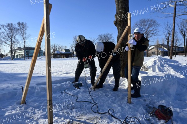 厳冬、短期のダブルで厳しい中、市内でポスター掲示板の設置準備に励む業者スタッフ（１７日、廣田佳那撮影）