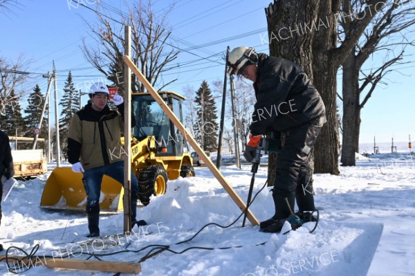 厳冬、短期のダブルで厳しい中、市内でポスター掲示板の設置準備に励む業者スタッフ（１７日、廣田佳那撮影）