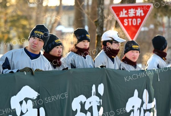 寒さに耐えながら、共通テストを受ける先輩を応援するために並ぶ帯広柏葉高校野球部員（１７日、帯広畜産大学で。塩原真撮影）