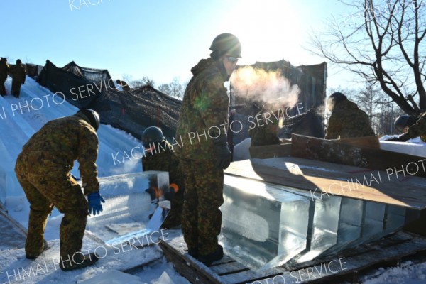 凍てつく寒さの中で「おびひろ氷まつり」の滑り台造りに奮闘する陸上自衛隊第５旅団の隊員たち（２２日、帯広市緑ケ丘公園で。金野和彦撮影）