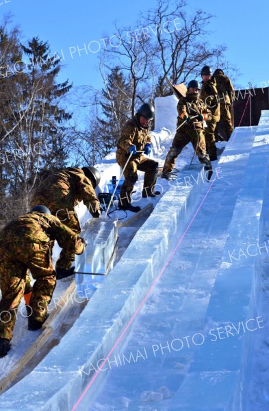 氷を引っ張り上げ、滑り台を造る隊員たち（２２日午前９時半ごろ。帯広市緑ケ丘公園で。金野和彦撮影）