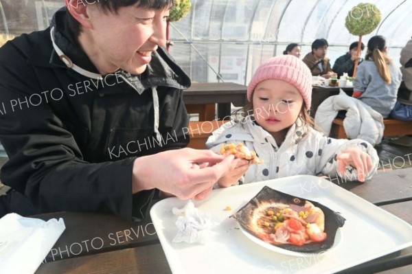 作ったピザを食べる親子